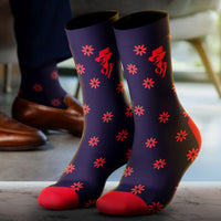 Pair of purple socks with red floral patterns worn indoors.